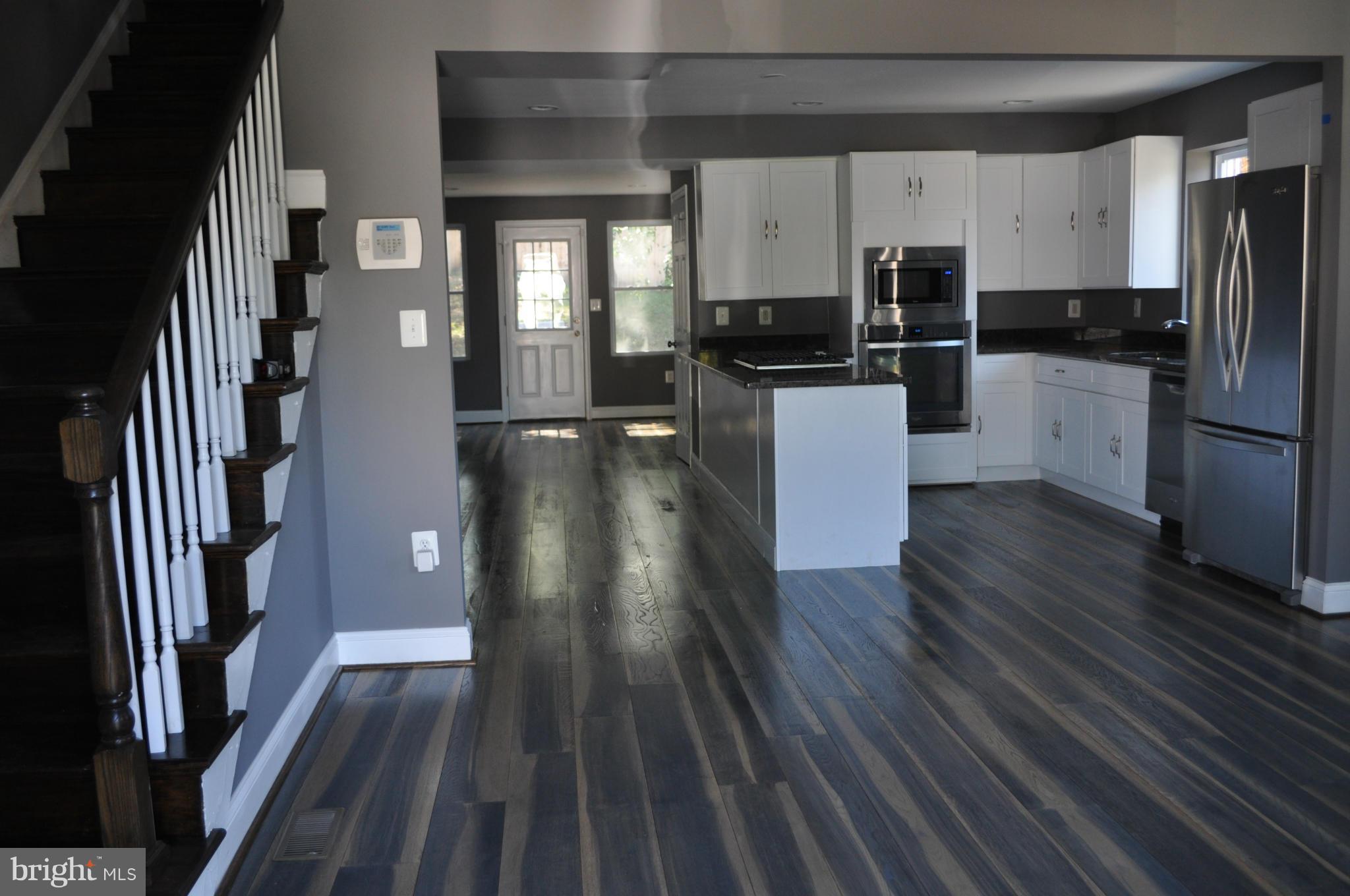 4909 Fitch Place Northeast Washington, DC 20019 - Photo 6 of 30 a kitchen with kitchen island wooden floors appliances and cabinets