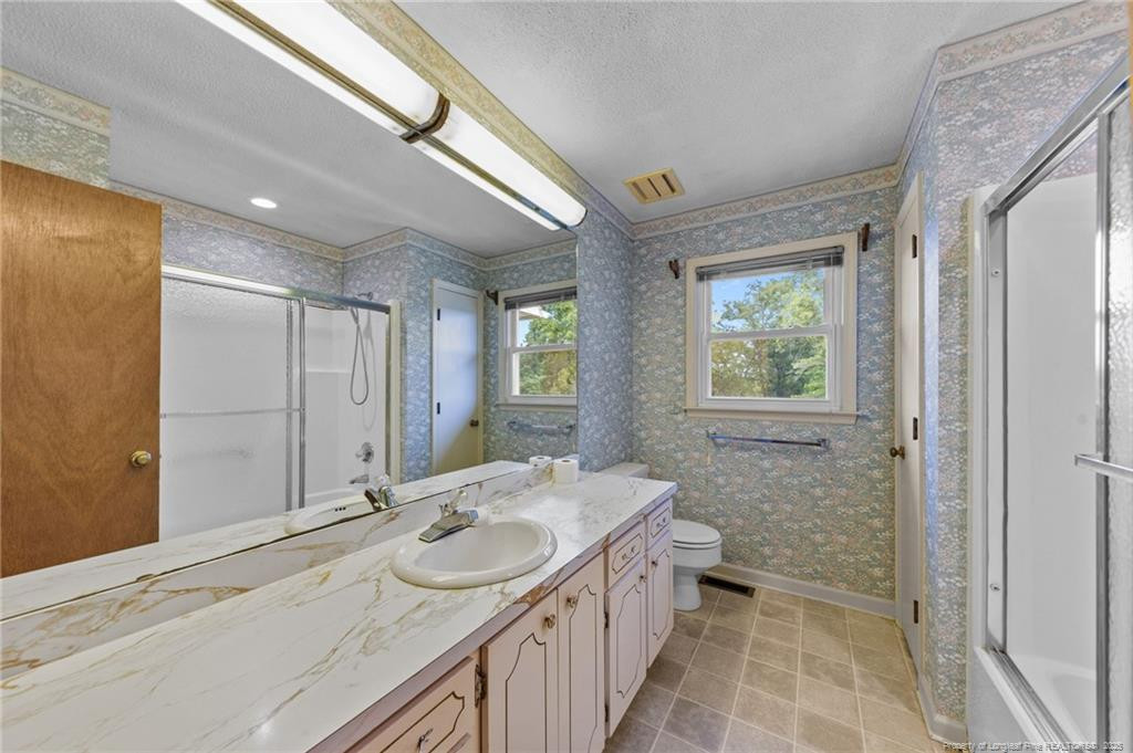 241 Hight Road Aberdeen, NC 28315 - Photo 18 of 48 a bathroom with a granite countertop sink a toilet and shower