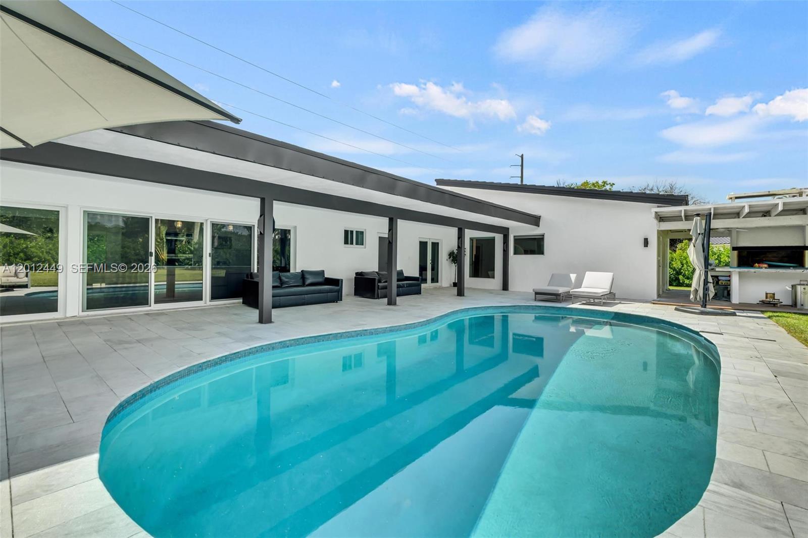 6200 Southwest 118th Street Pinecrest, FL 33156 - Photo 52 of 69 a swimming pool with outdoor seating yard and barbeque oven
