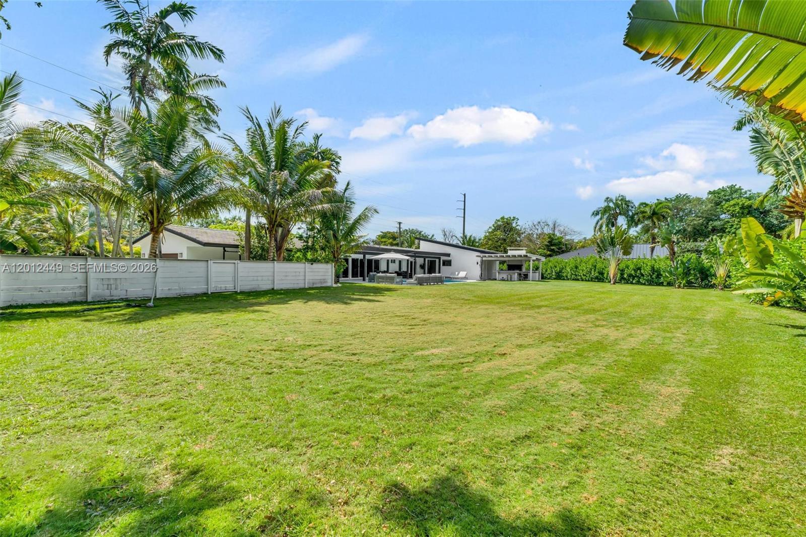 6200 Southwest 118th Street Pinecrest, FL 33156 - Photo 55 of 69 a view of a swimming pool with a yard and palm trees