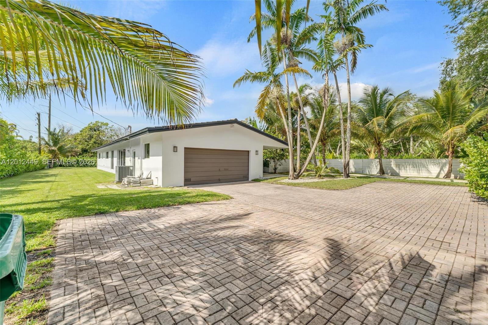 6200 Southwest 118th Street Pinecrest, FL 33156 - Photo 7 of 69 a front view of a house with a yard and garage