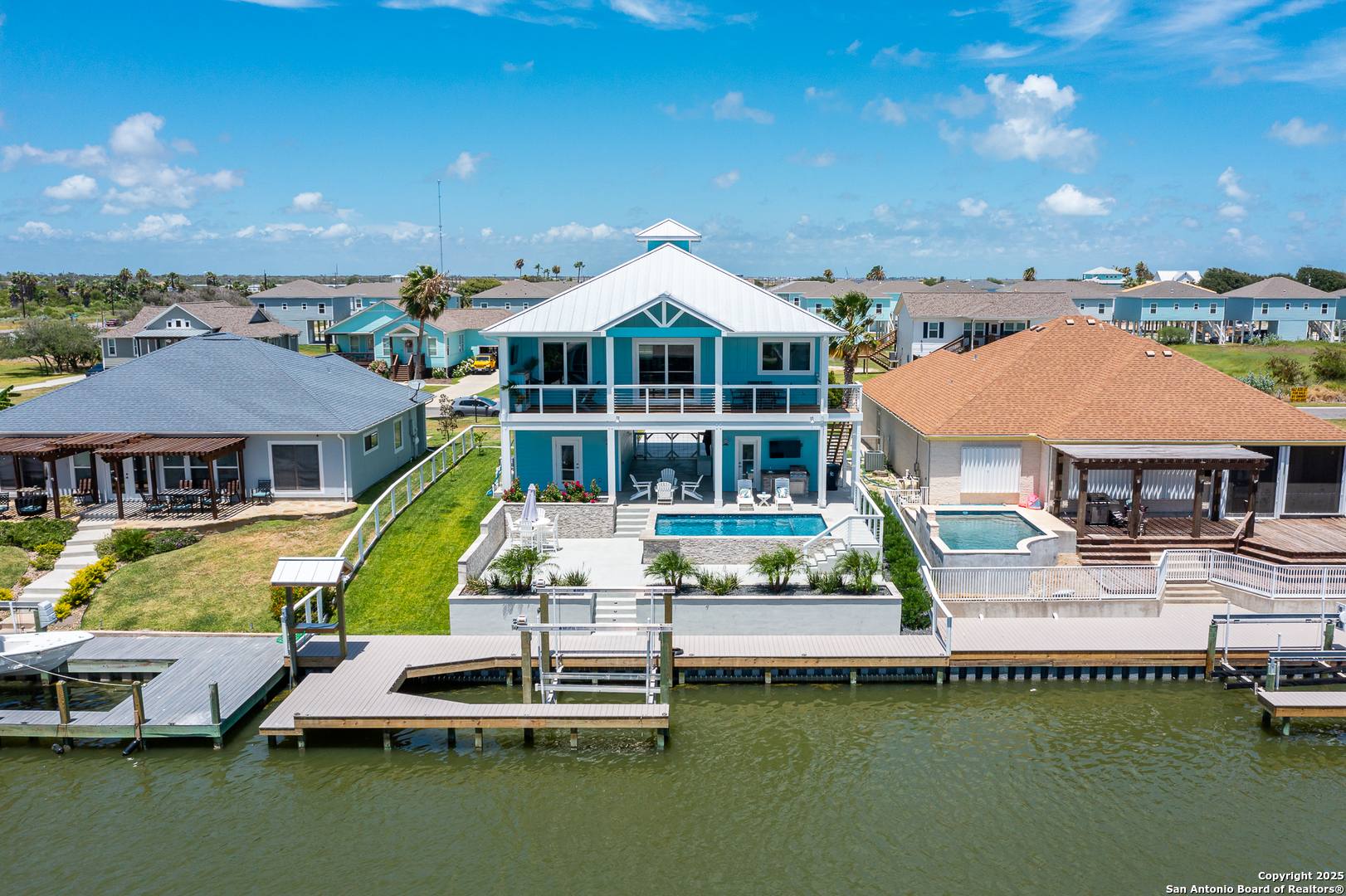 107 Windjammer Road Rockport, TX 78382 - Photo 26 of 52 a view of a house with pool lawn chairs and a yard