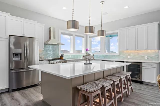 a kitchen with stainless steel appliances a sink stove and wooden floor