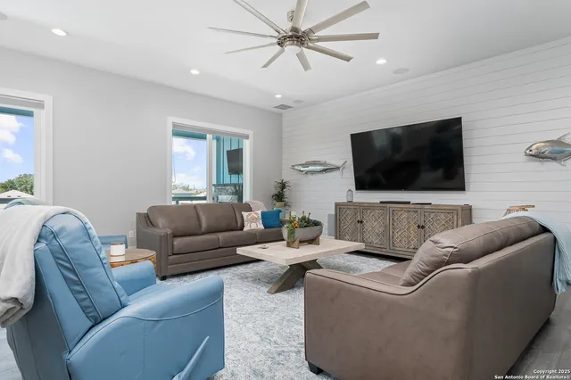 a living room with furniture kitchen view and a chandelier