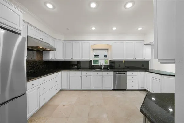 a large kitchen with a window and stainless steel appliances