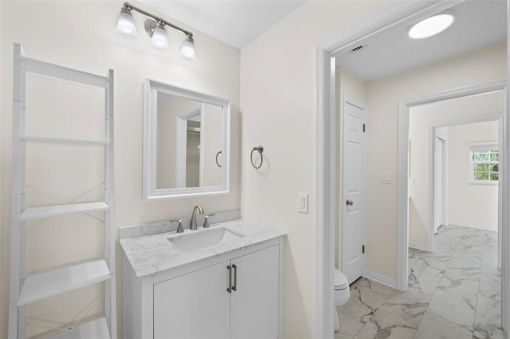 4913 Andros Drive Tampa, FL 33629 - Photo 33 of 57 a bathroom with a granite countertop sink a mirror and a shower