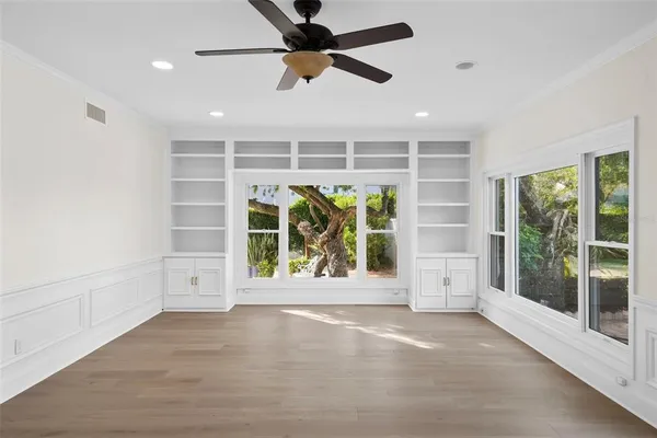 a view of an empty room with a window and a ceiling fan