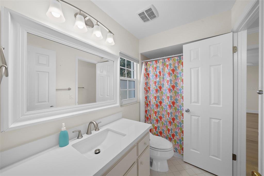 4913 Andros Drive Tampa, FL 33629 - Photo 46 of 57 a bathroom with a sink a toilet and shower curtain
