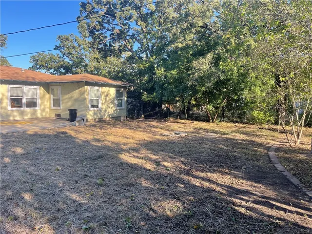 a view of a yard with a house and large tree
