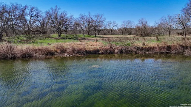 an aerial view of a house with a yard and lake view