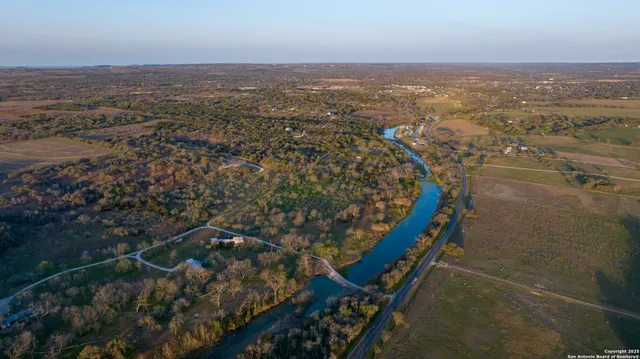 an aerial view of house with yard and mountain view in back
