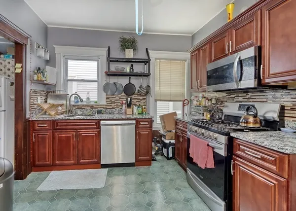 a kitchen with stainless steel appliances granite countertop a sink stove and cabinets