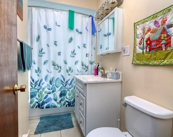 a bathroom with a toilet a sink and a shower curtain