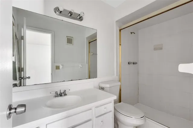 a bathroom with a toilet sink a mirror and shower