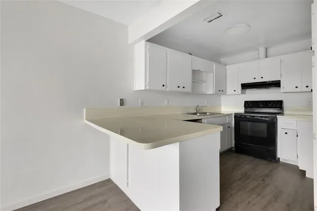 a kitchen with granite countertop a sink cabinets and stainless steel appliances