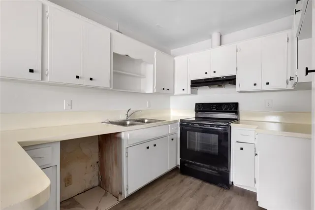 a kitchen with cabinets appliances and a sink