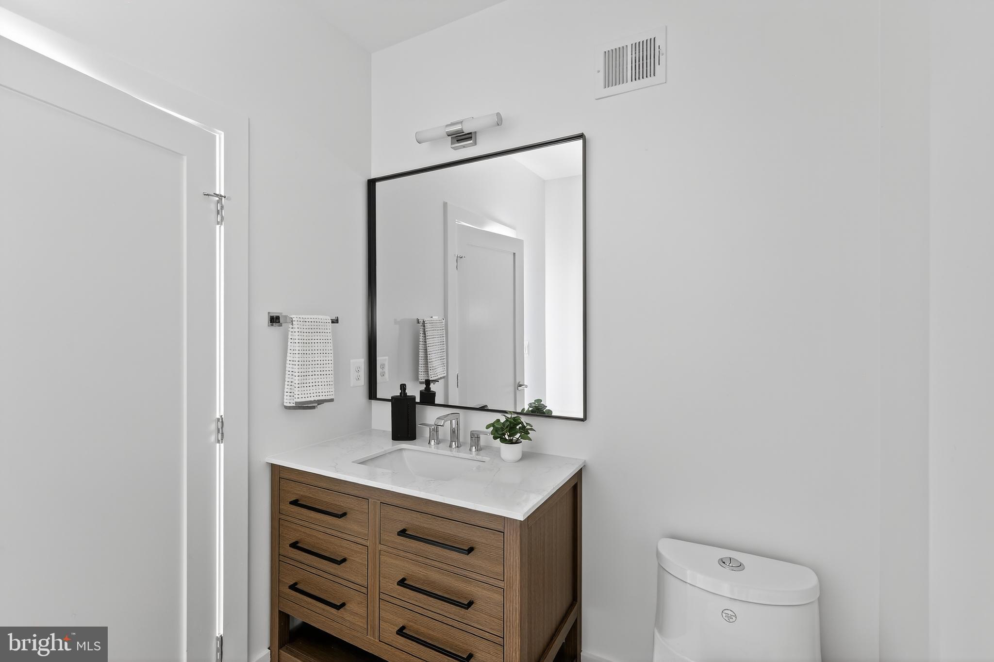 828 21st Street Northeast, Unit 2 Washington, DC 20002 - Photo 24 of 27 a bathroom with a sink a toilet and mirror