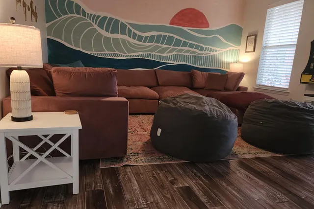 a living room with furniture and a wooden floor