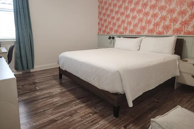 a large bed sitting in a bedroom next to a window