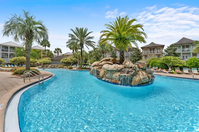 a view of a swimming pool with a garden and patio