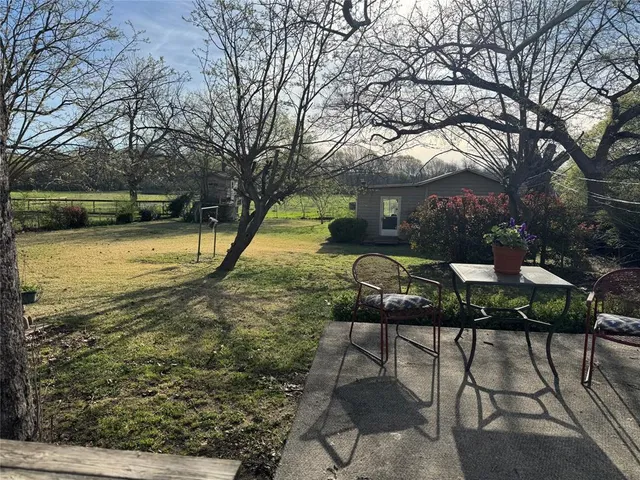 a backyard of a house with table and chairs