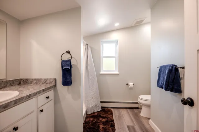 a bathroom with a granite countertop sink toilet and shower