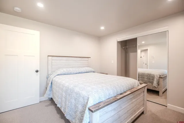 a bedroom with a bed and a mirror