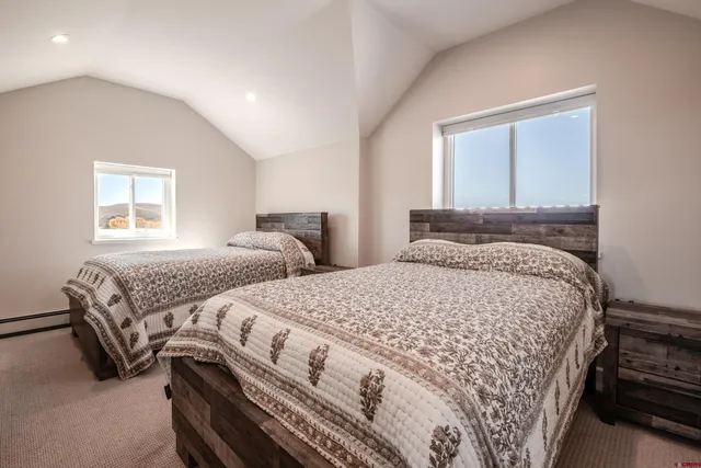 a bedroom with two beds and a window