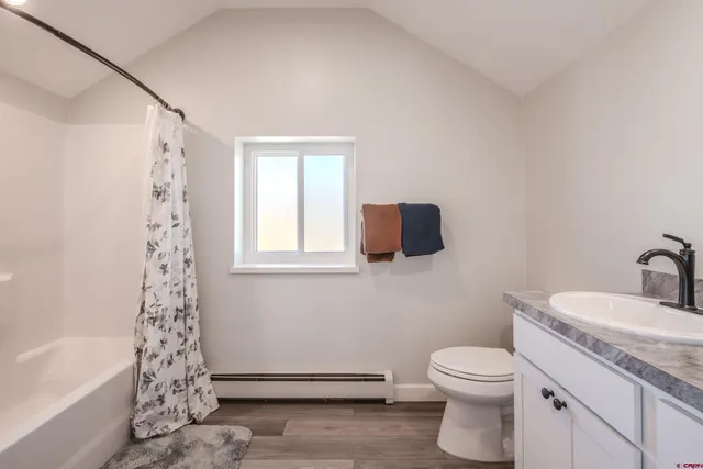a bathroom with a granite countertop sink a toilet and bathtub