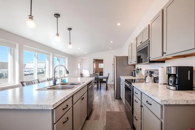 a kitchen with stainless steel appliances granite countertop a sink stove and refrigerator