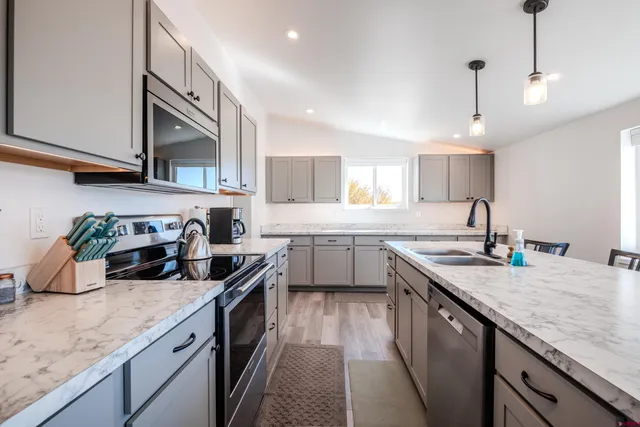 a kitchen with a sink dishwasher a stove and a refrigerator with wooden floor