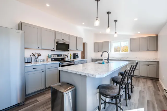 a kitchen with granite countertop a sink stainless steel appliances and white cabinets