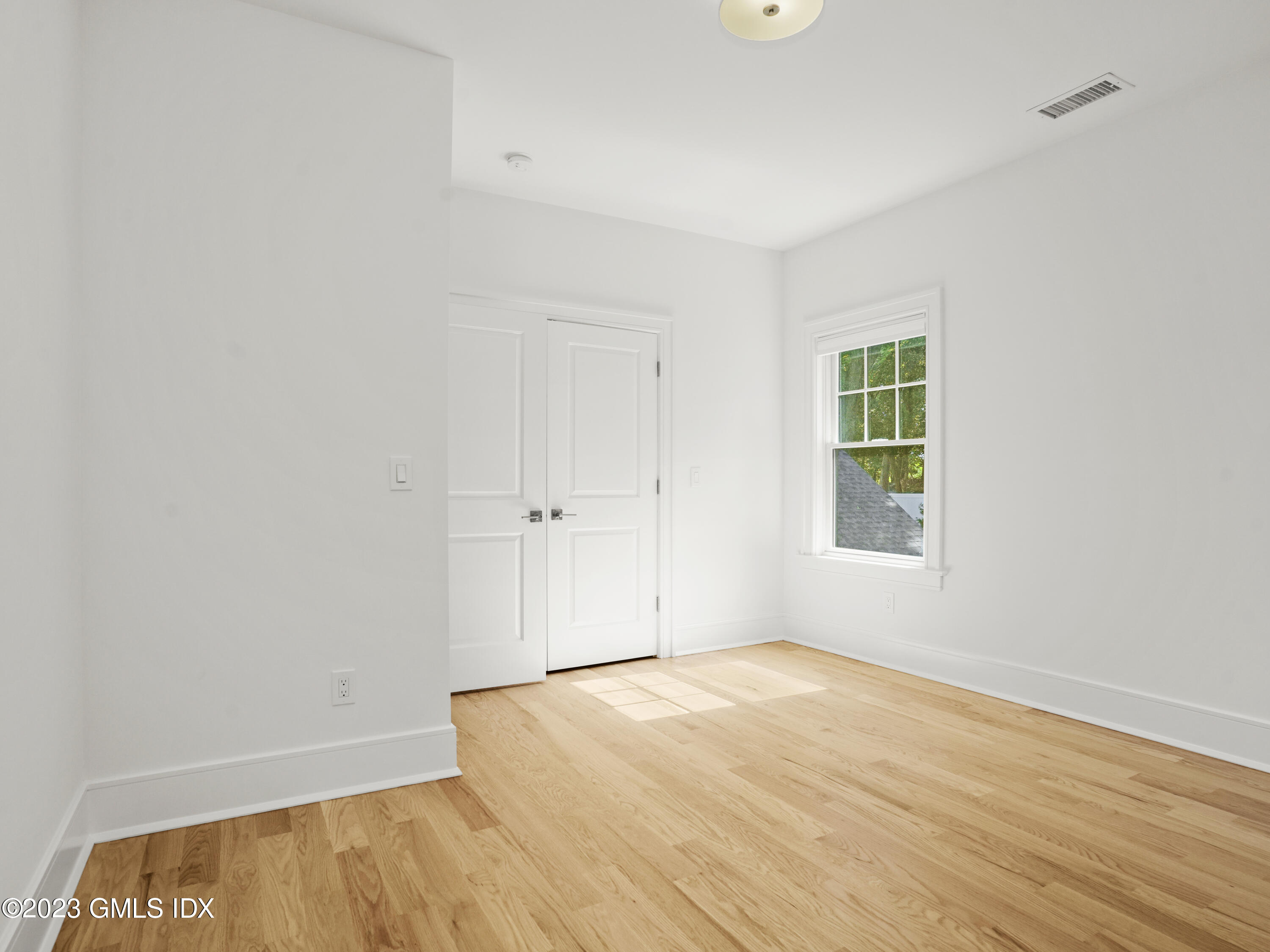 40 Butler Street Cos Cob, CT 06807 - Photo 12 of 27 an empty room with wooden floor and windows