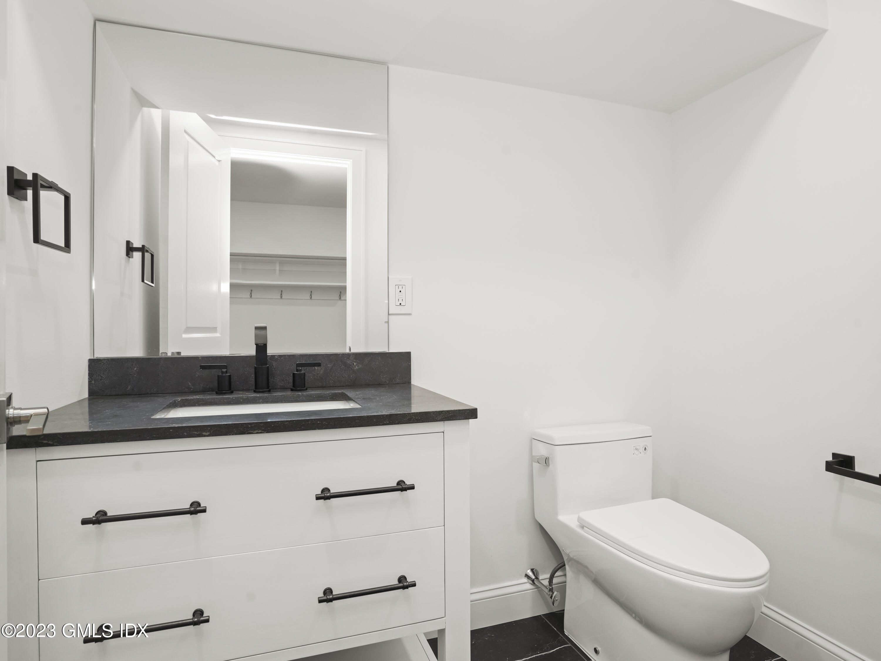 40 Butler Street Cos Cob, CT 06807 - Photo 23 of 27 a bathroom with a granite countertop toilet sink and mirror