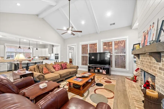 a living room with furniture a fireplace and a flat screen tv