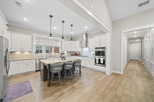 a dining hall with stainless steel appliances kitchen island granite countertop a dining table chairs and view living room