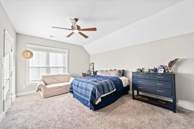 a spacious bedroom with a bed and large window