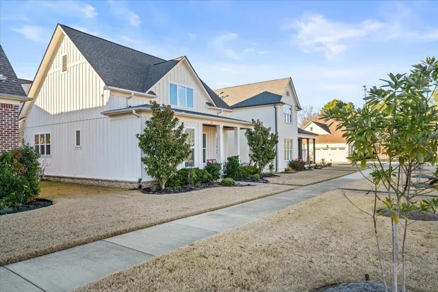 a front view of a house with a yard and potted plants