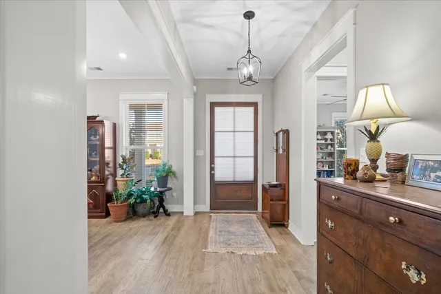 a view of a hallway with wooden floor and chandelier