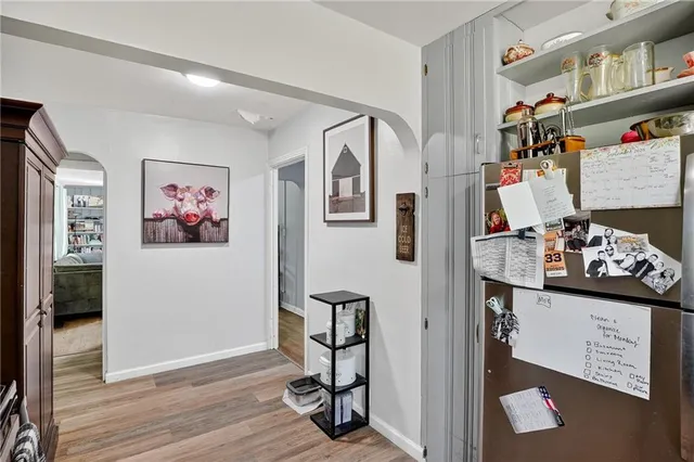 a view of a hallway with workspace and wooden floor