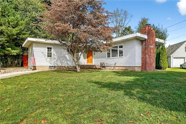 a backyard of a house with large trees and barbeque oven