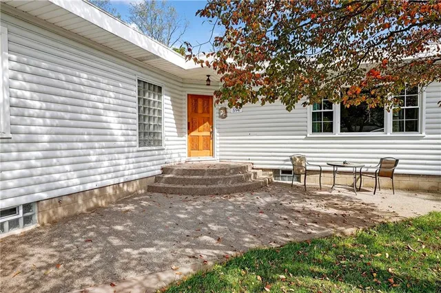 a view of house with backyard and sitting area