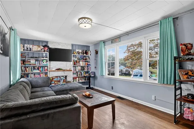 a living room with furniture a flat screen tv and a window
