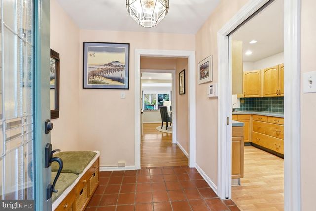 a view of a hallway with a dining table & chairs