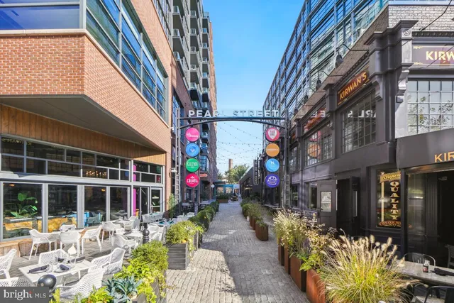 a front view of a multi story building with yard and outdoor seating