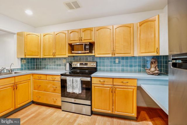 a kitchen with stainless steel appliances granite countertop a sink a stove and cabinets