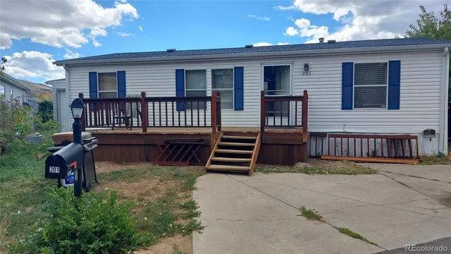 a view of a house with a small yard and wooden fence