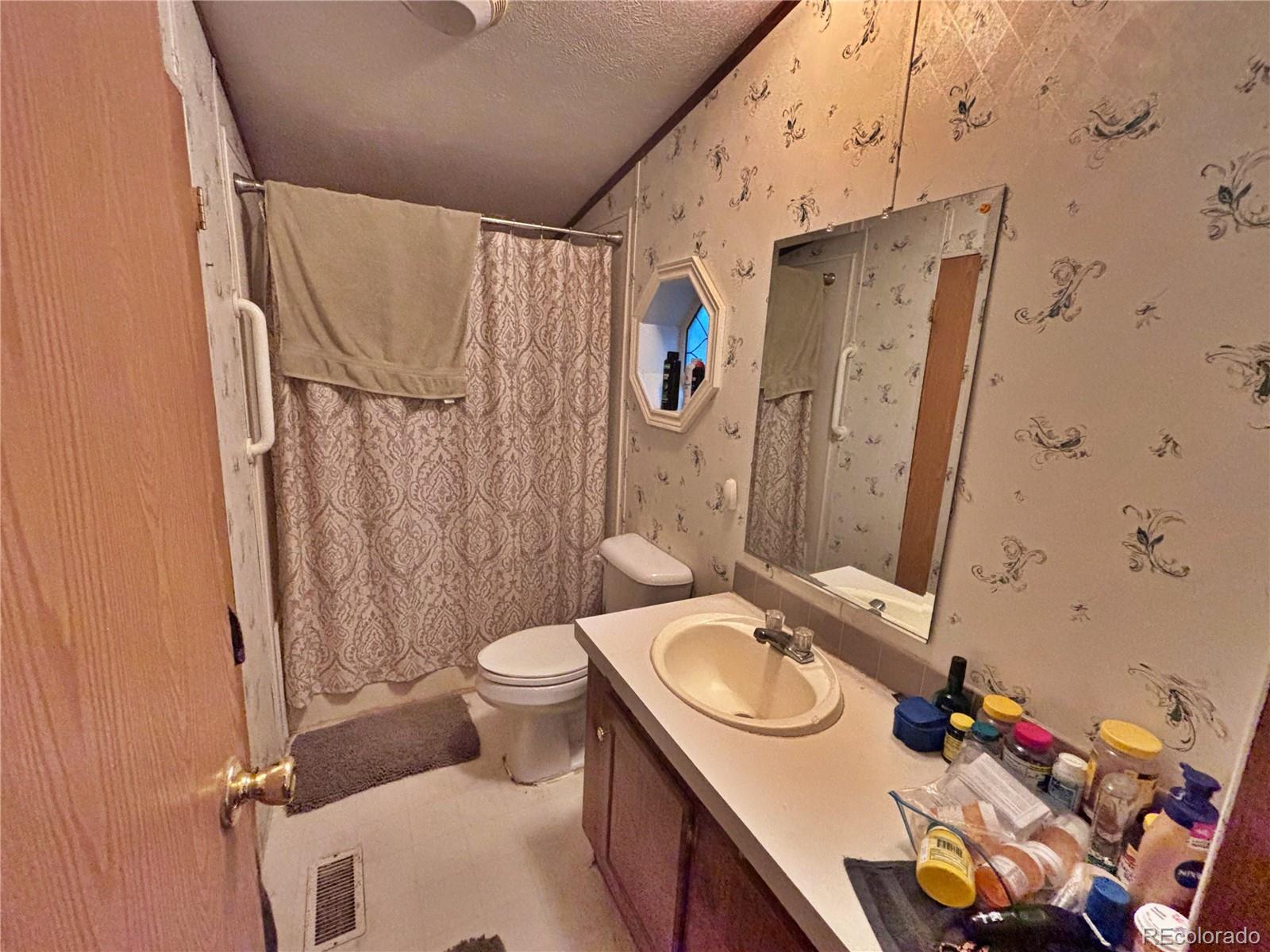 201 Pinto Street Golden, CO 80401 - Photo 13 of 22 a bathroom with a granite countertop sink toilet and shower