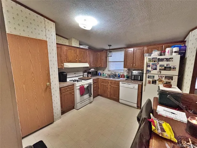 a kitchen with a refrigerator a stove a sink dishwasher and a microwave