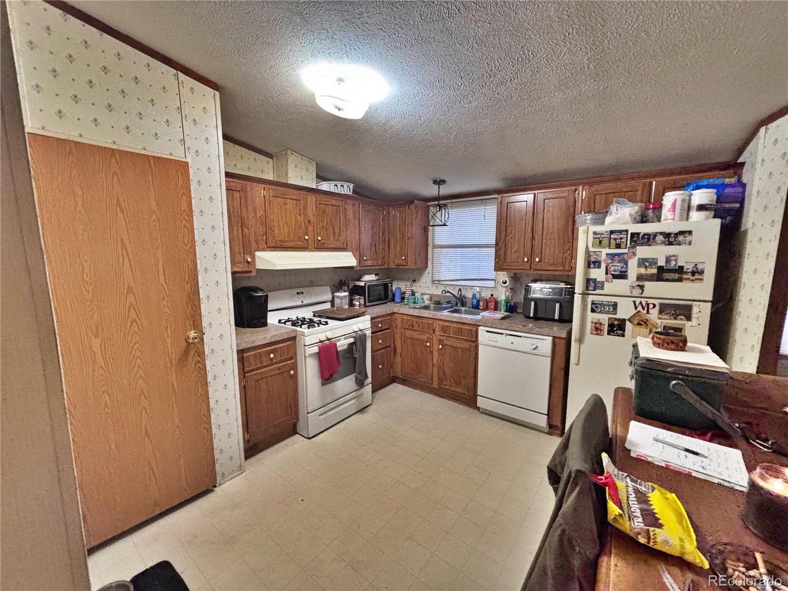 201 Pinto Street Golden, CO 80401 - Photo 18 of 22 a kitchen with a refrigerator a stove a sink dishwasher and a microwave